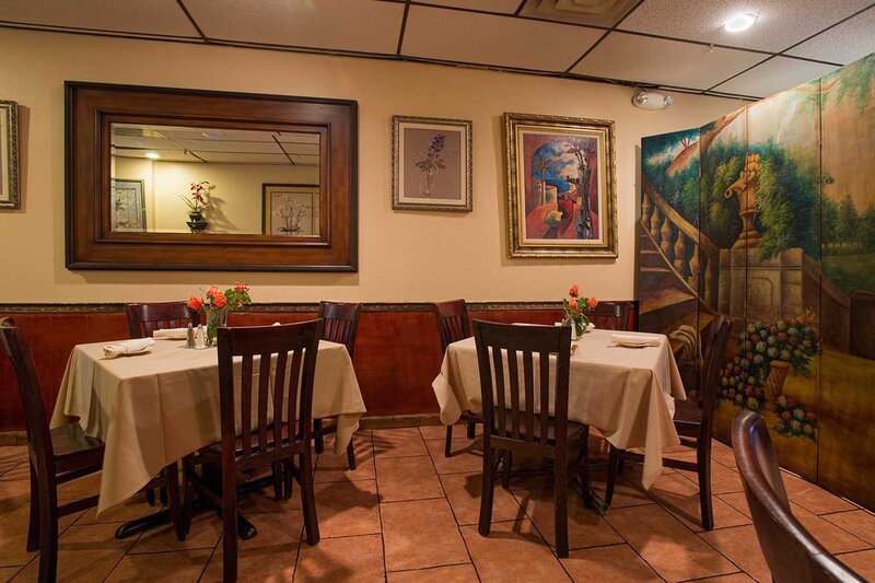 Dining room with two set tables with seating for four